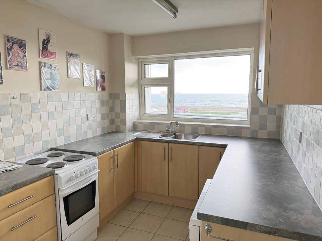 Lot: 126 - TWO-BEDROOM TOP FLOOR FLAT WITH UNINTERRUPTED SEA VIEWS - Fitted kitchen with view out to the beach